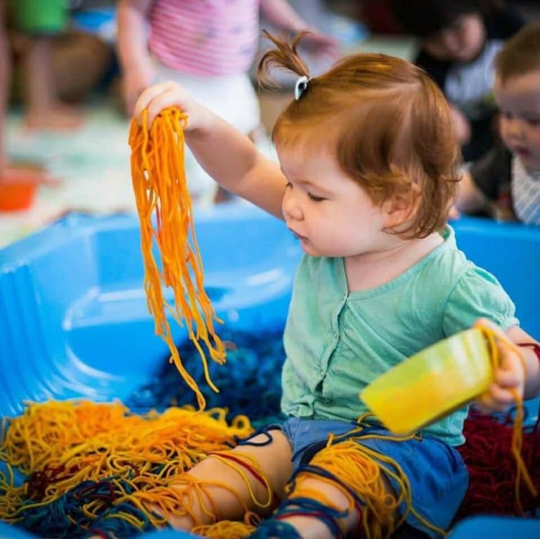toddler playing with spagetti