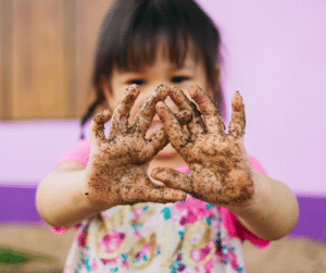Toddler having sensory fun with dirty hands 