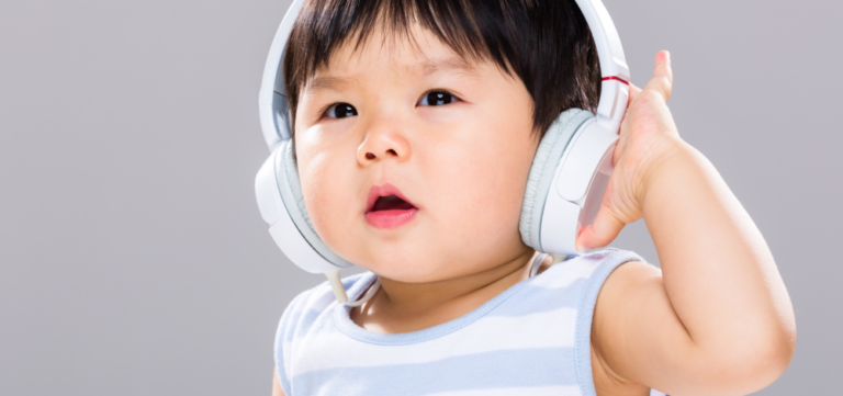 Young child listening to relaxing music from white headphones