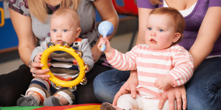 Babies having fun with musical instruments in a class with parents
