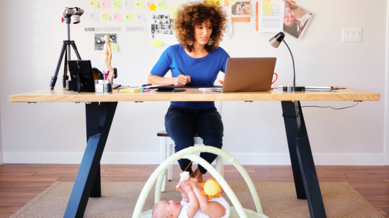 Mom work-life at table with laptop and child on floor
